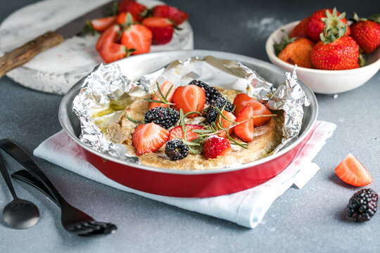 French cuisine. Baked camembert cheese with strawberry on a light background, banner, menu, recipe place for text.