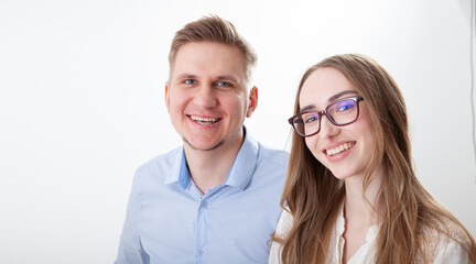 Successful young business partners looking at camera. Portrait of a smiling group of diverse corporate colleagues standing in a row together at a table in a bright modern office.