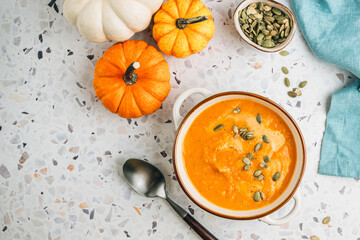 Roasted pumpkin and carrot soup with cream and pumpkin seeds