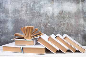 Open books, hardback colorful books on wooden table. gray concrete background. Back to school. Copy...