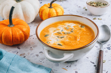 Roasted pumpkin and carrot soup with cream and pumpkin seeds