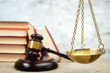 Law concept - Open law book, Judge's gavel, scales on table in a courtroom or law enforcement office.