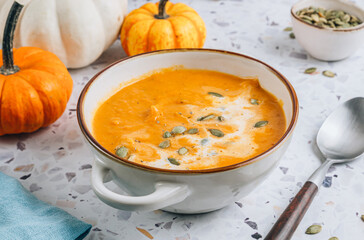 Roasted pumpkin and carrot soup with cream and pumpkin seeds