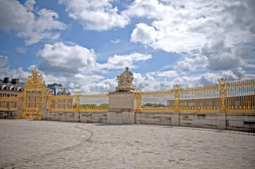 The golden doors and white marble statues of Versailles castle in the city of Paris - PARIS, FRANCE - June 27, 2012.