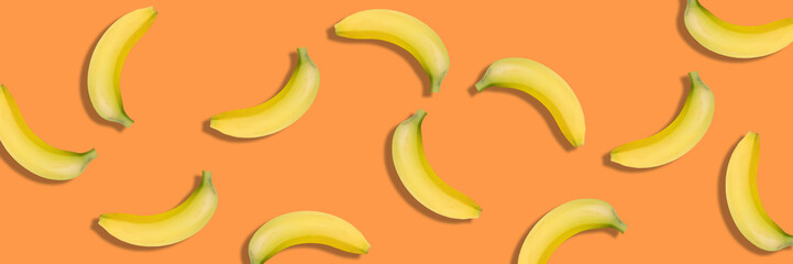 Banana isolated on orange background. panorama, banner. Bananas texture design for textiles,...