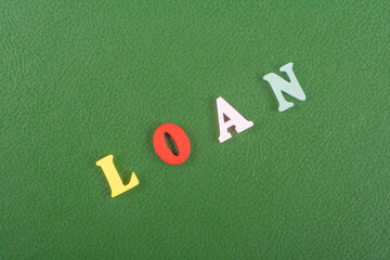 LOAN word on green background composed from colorful abc alphabet block wooden letters, copy space for ad text. Learning english concept.