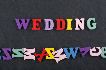 WEDDING word on black board background composed from colorful abc alphabet block wooden letters,...