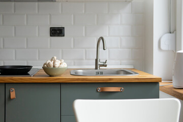 modern kitchen with wooden countertop. mushrooms in a plate with the kitchen in the background.