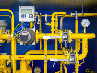 Gas infrastructure. Yellow pipes inside metal cabinet. Gas compressor unit. Pipes with mechanical and electronic sensors. Gas unit for supplying factory with propane. Gasification of premises