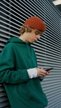 Contemporary teenager texting phone outdoors closeup