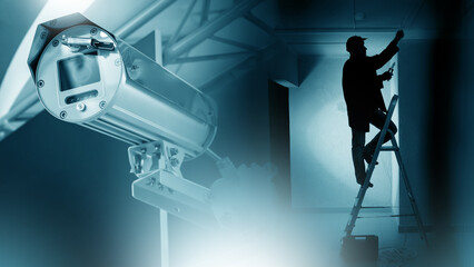 Installation of video surveillance system. CCTV camera. Master is standing on stepladder. Man...
