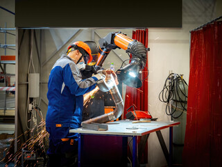 Men work in pipe production. Factory workers prepare pipeline for gas infrastructure. Men process...
