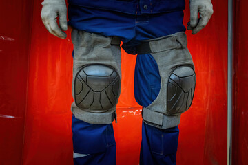 Protective knee pads on worker legs. Uniforms for industrial safety. Knee pads to protect legs of...
