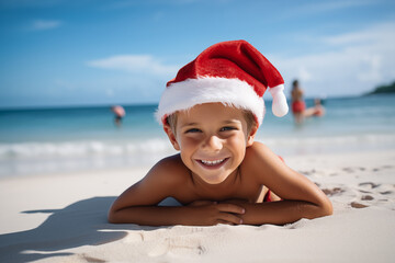 Photo of happy kid on the beach wearing Santa Claus hat - obrazy, fototapety, plakaty