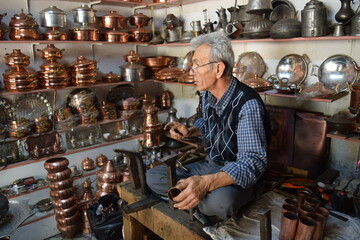 A tinsmith, in his, tinsmith's shop,The master, of working, with copper, in his shop