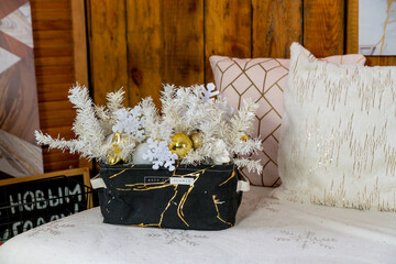 Details of the Christmas interior. Textile basket with a Christmas composition of white spruce twigs, snowflakes, balls.