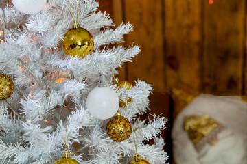 Details of the Christmas interior. Branches of a white Christmas tree with golden and white balls.