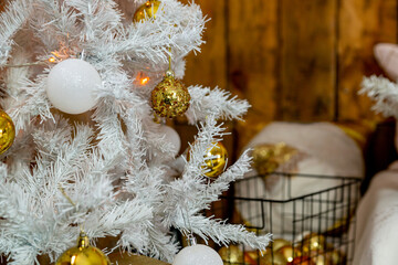 Details of the Christmas interior. Branches of a white Christmas tree with golden and white balls.