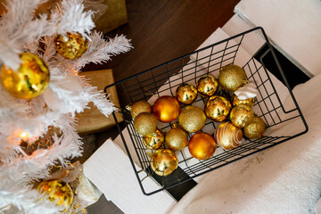 Details of the Christmas interior. Metal basket with golden Christmas balls.