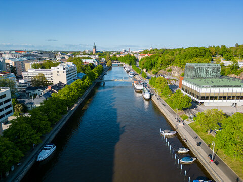 Aerial view over Aurajoki in downtown Turku with lush green trees during a summer day