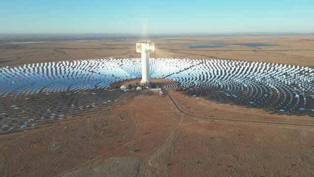 Solar rays reflect off grid of mirrors onto concentrated solar tower in Kalahari desert near Upington