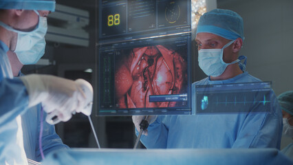 Surgeons operate patient in modern hospital operating room. Doctors perform heart surgery using 3D...