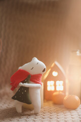 Christmas mood concept. Cozy composition with plaid, toy bear, tangerines and traditional festive decorations