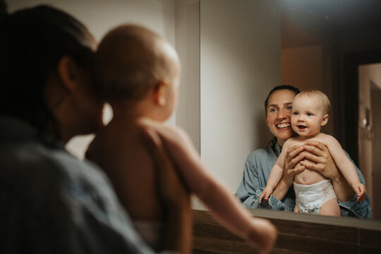 Mother and baby looking in mirror after shower