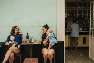 Mothers with babies relaxing in sidewalk cafe