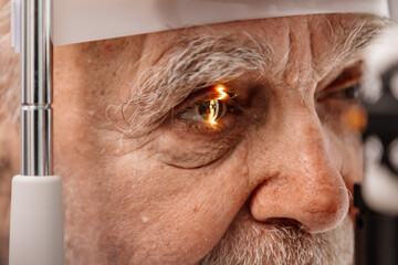 Close-up of an eye on an ophthalmology examination of an elderly man. The concept of advertising...