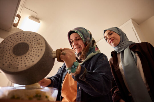 Mother and daughter cooking together for eid al-fitr at home