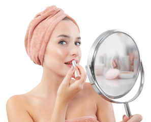 Makeup, smiling young pretty woman applying the red lipstick on the lips, wears a towel wrapped on head and with her big blue eyes looks at mirror that is held in hand. Isolated on white background