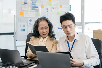 Obraz premium Businessmen write project ideas and use laptops to edit papers for brainstorming sessions with partners in the office.