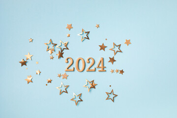 2024 New Year and Christmas background with golden confetti stars top view.
