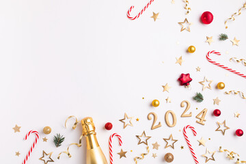 Christmas and New Year composition with golden champagne bottle, party streamers, confetti stars, fir tree, holiday decorations and 2024 numbers. Flat lay style. - obrazy, fototapety, plakaty