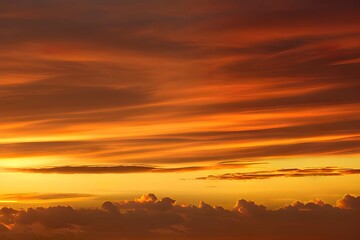 Fototapeta premium 夕焼けの空に映る雲のグラデーション、深紅から明るいオレンジまでの色彩が美しい夜の幕開け