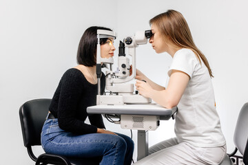 An ophthalmologist checks a young woman's vision using modern equipment. Concept for advertising...