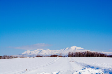 晴れた日の冬の丘陵地帯と雪山　大雪山
