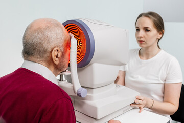 An ophthalmologist examines the eyes of an elderly patient using modern technology in an...