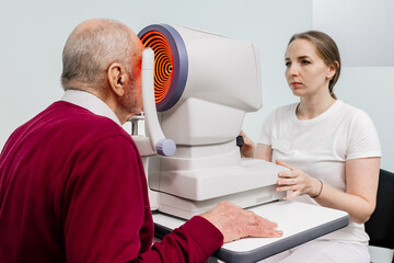 An ophthalmologist checks the vision of an elderly person using modern equipment. The concept of...