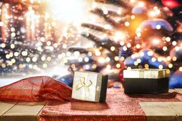 Wooden table of free space for your decoration. Golden boxes of christmas gifts. Blurred background...