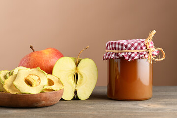 Jar of jam, plate with apple chips and fresh apples