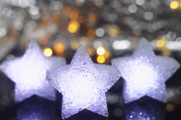 white and blue stars on a bokeh background, background with a star, on the eve of Christmas,...