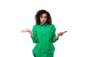 pretty young business woman dressed in a green shirt holding a smartphone and spreading her arms