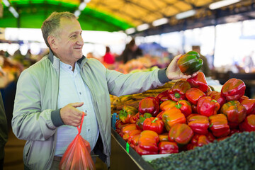 Man purchasing peppers in greengrocery