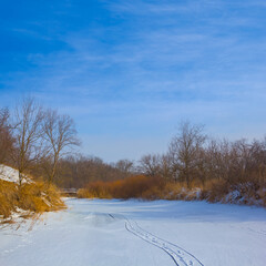 Obraz premium frozen winter river under a blue cloudy sky