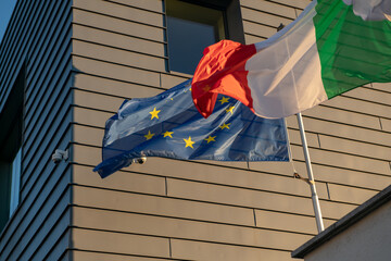 flags of the European Union and Italy are now flying in all official national offices. symbol of...