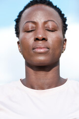 Head-shot of strong black woman outdoors.