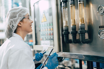Worker in drinking water plant clean hygiene drink factory quality control monitoring flow meter...
