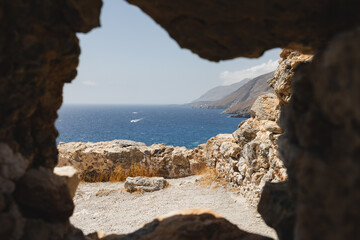 Obraz premium Crete coastline through a ruin, Greece